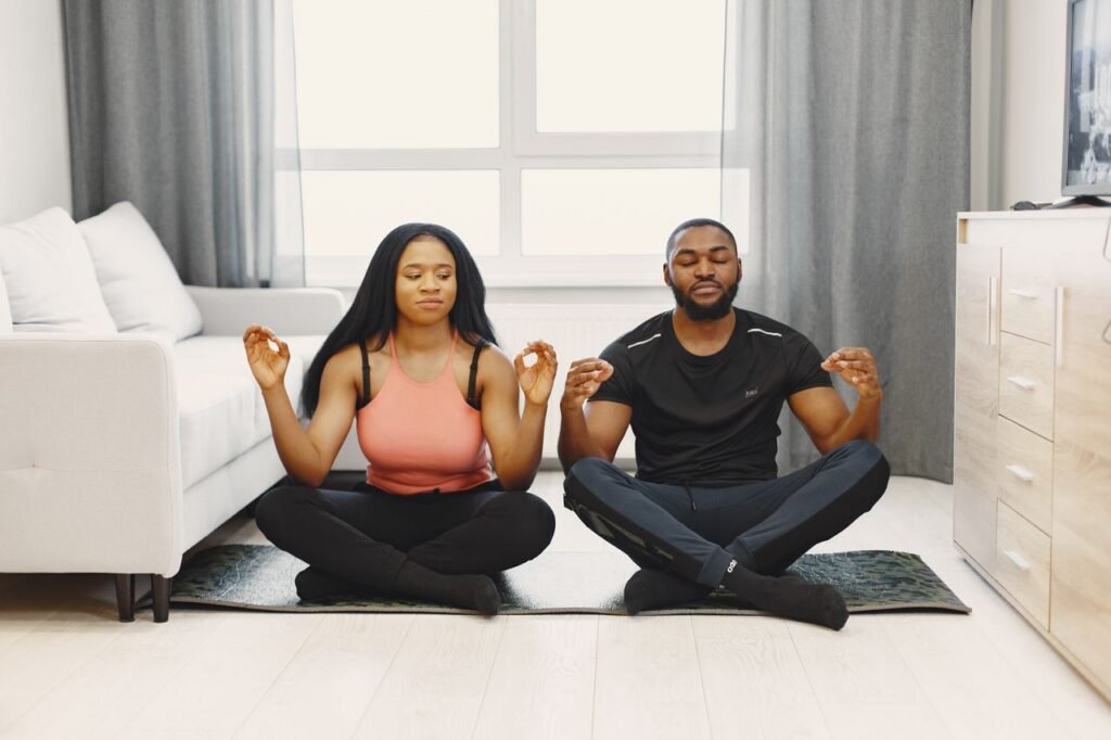 pexels-photo-6496095-6496095 A couple meditating on yoga mats in a bright modern living room. Serenity and relaxation.
